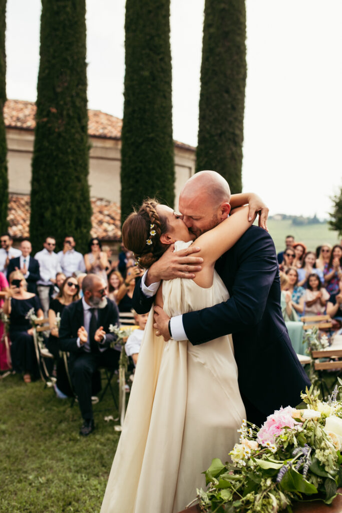 Bride and groom kiss passionately in a picturesque setting in Langhe, Piedmont