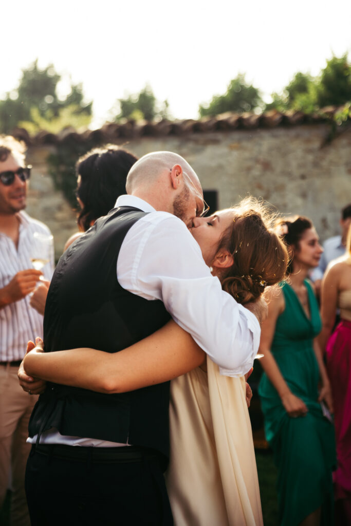 Bride and groom kiss between the guests