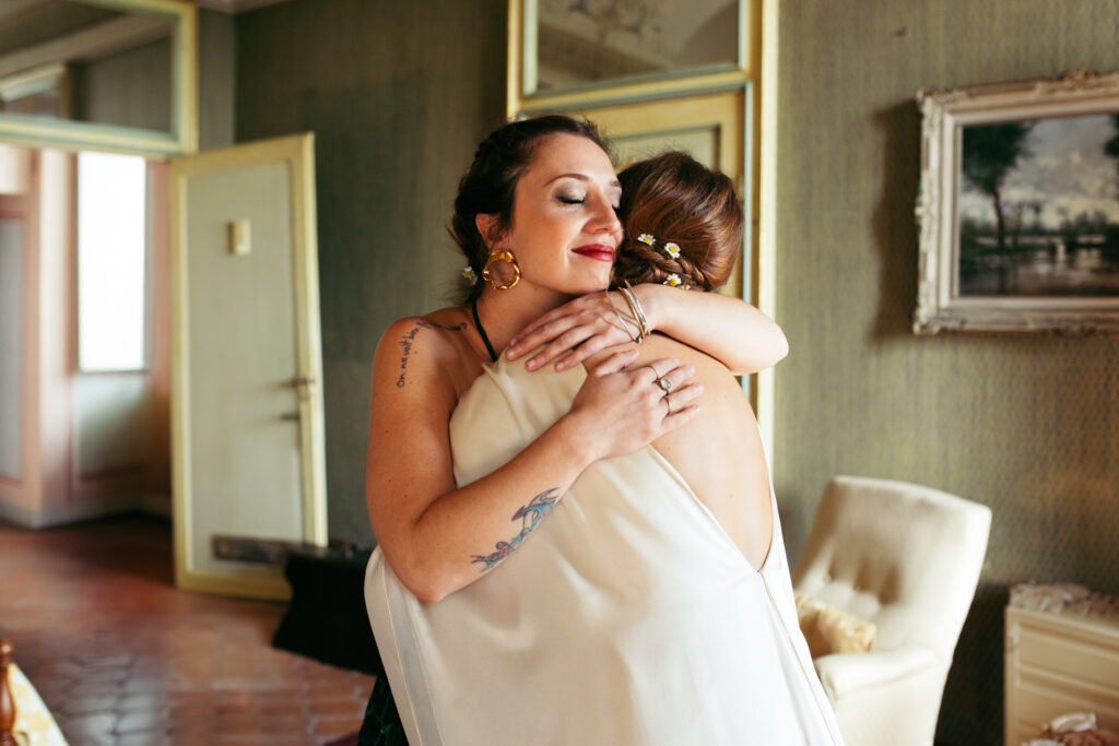 Bride and bridesmaid hug before the wedding ceremony