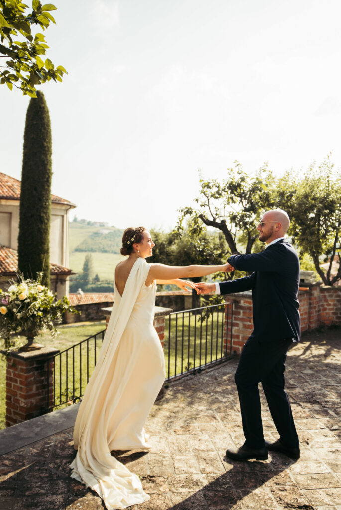 Bride and groom have a little dance alone against the countryside backdrop of Langhe region