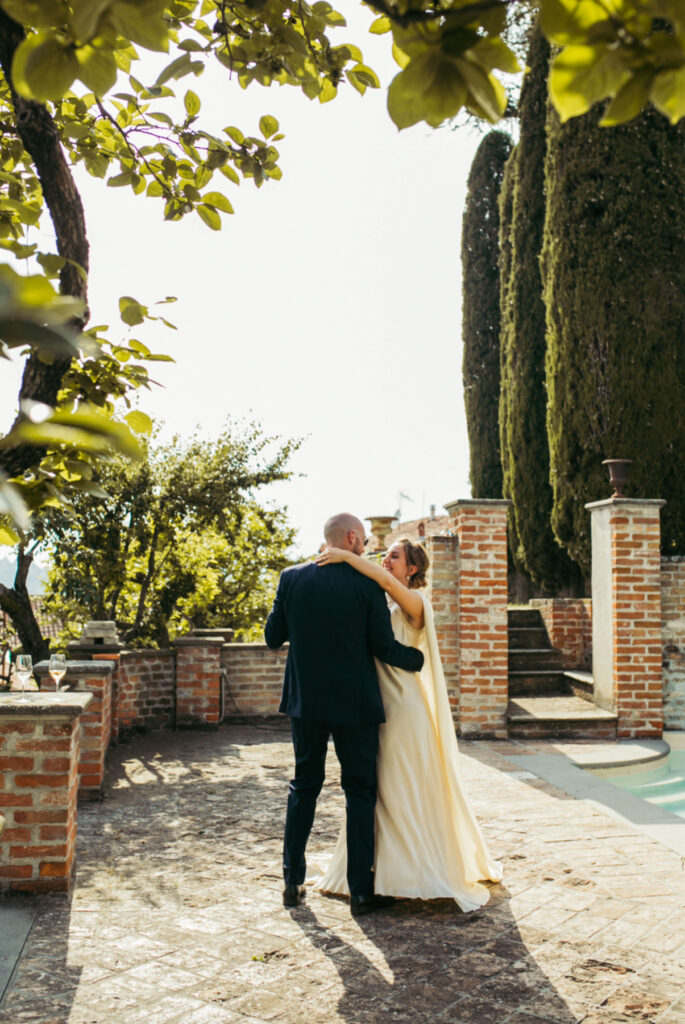 Bride and groom have a little dance alone against the countryside backdrop of Langhe region during wedding couple photoshoot