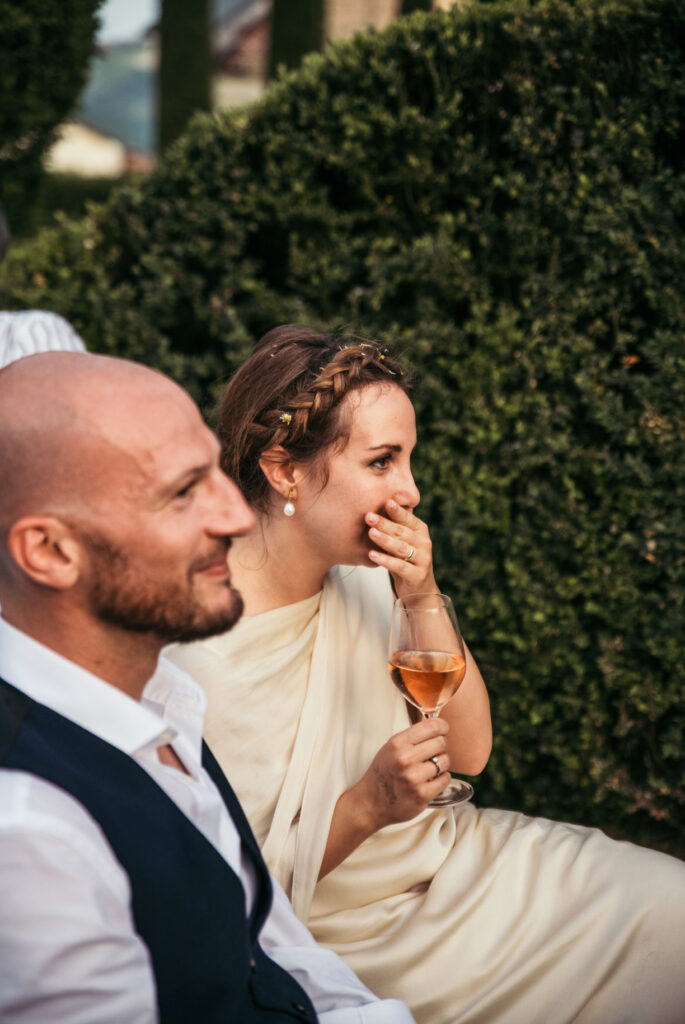 Groom and bride listen to their guests' speeches while getting emotional