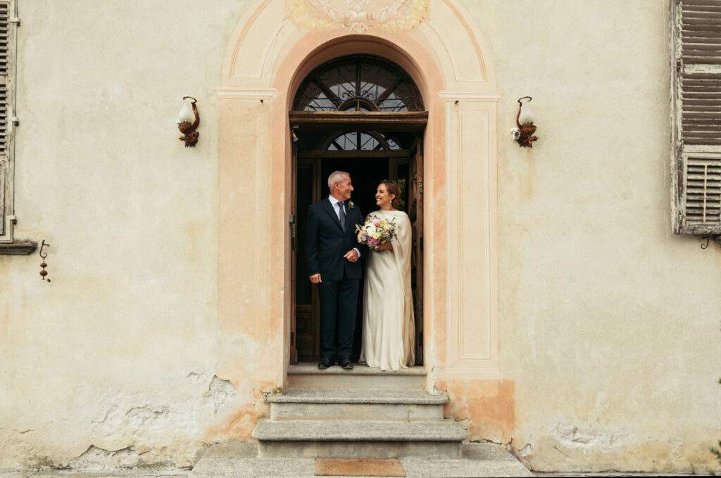 Bride and her dad smiling at each other before getting to the ceremony spot