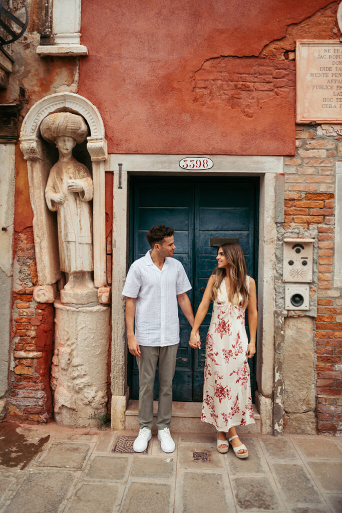 Couple posing in front of a beautiful door in Venice Italy