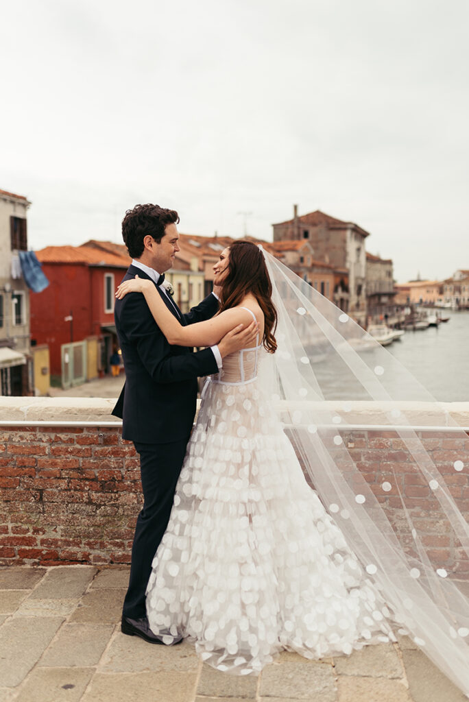 Newly-wed couple dancing on a bridge in Murano island, Venice