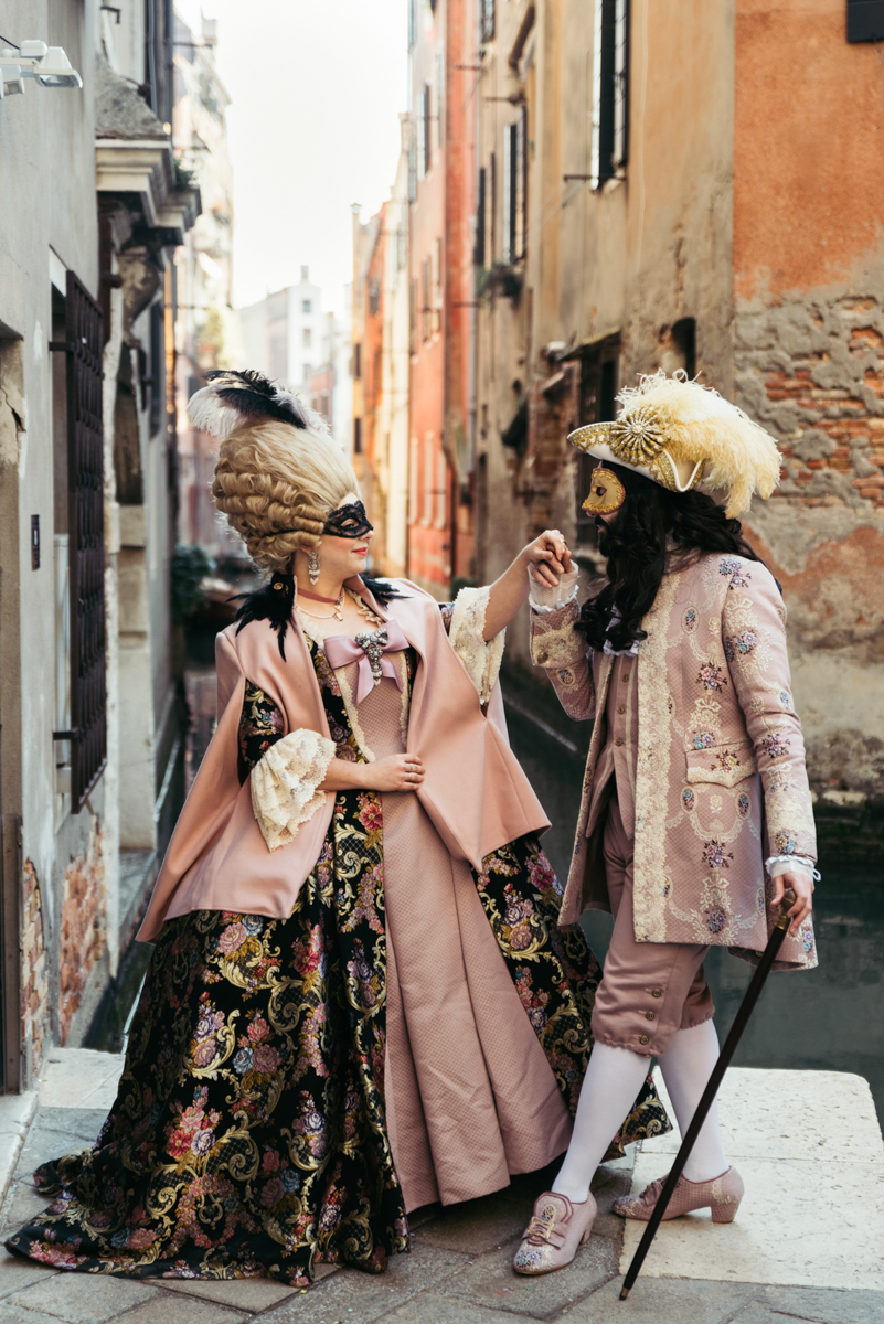 A couple in traditional Venetian Carnival costumes posing for a photoshoot in Venice