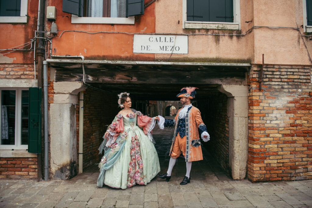 Two lovers dancing in Venice wearing Carnival costumes