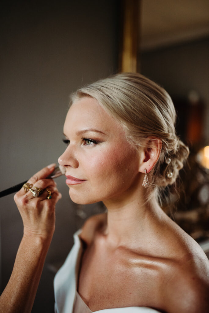 Close-up of the bride having her makeup done, focusing on her eye makeup during the preparation.