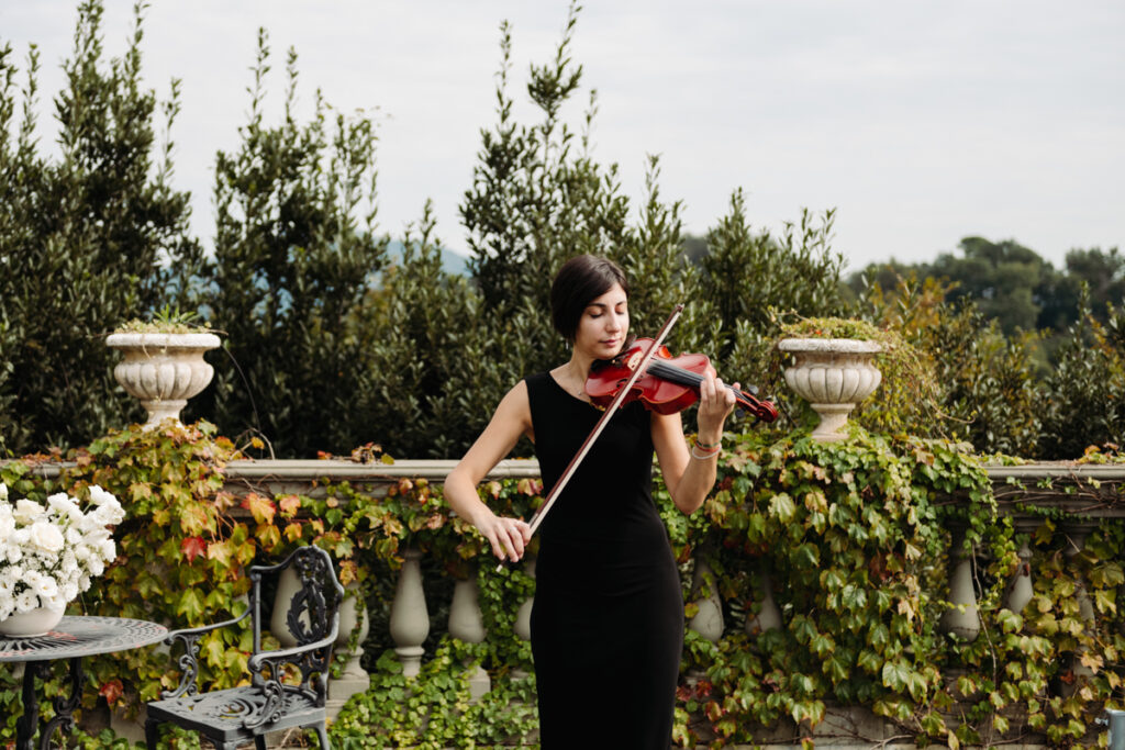 Violinist playing with passion during the ceremony, adding a romantic touch to the intimate elopement.