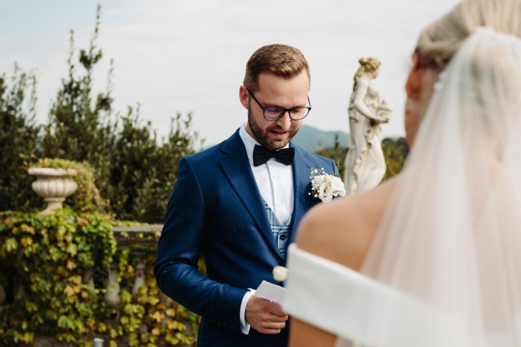 The groom smiling tenderly, captured from behind the bride’s shoulder during an intimate moment.