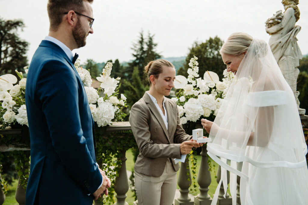 The celebrant gives the ring to the bride