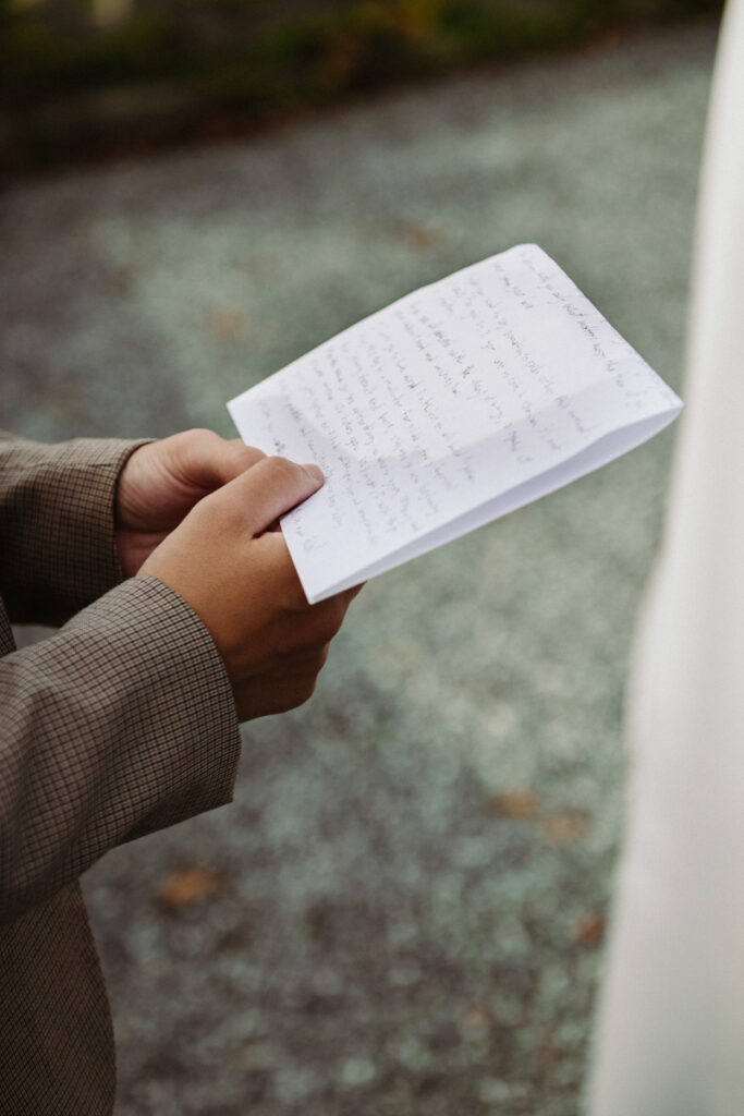 Close-up of handwritten vows held by the celebrant during the symbolic ceremony.