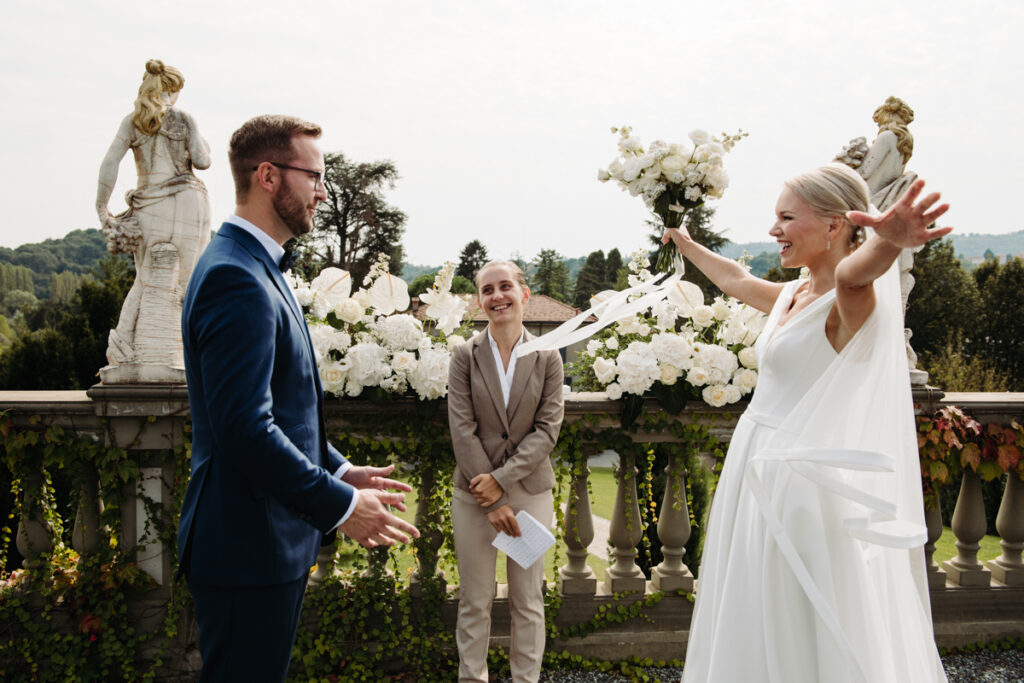 The bride runs to hug the groom with the celebrant on the background