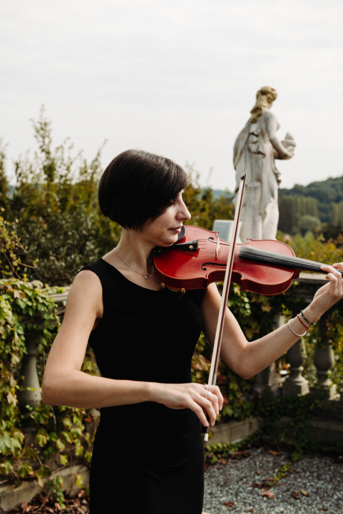 Violinist in a black dress playing during the elopement in Italy