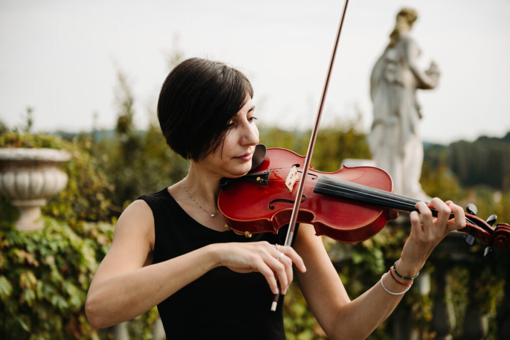 Violinist playing during the ceremony, creating an intimate and refined atmosphere