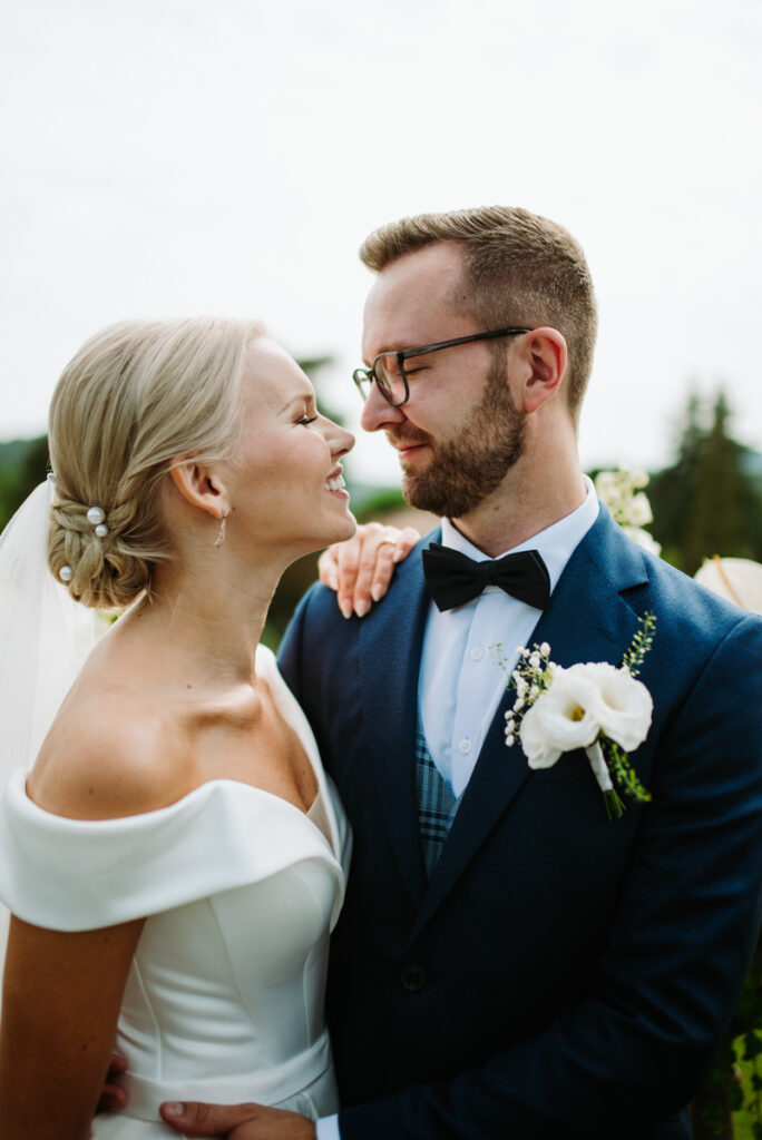 Close-up of the couple looking into each other's eyes, the bride smiling as she touches the groom's shoulder