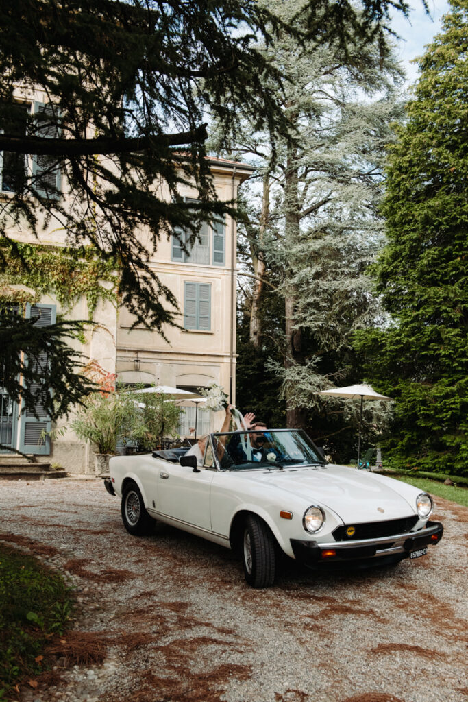 Vintage white convertible parked in front of an elegant Italian villa