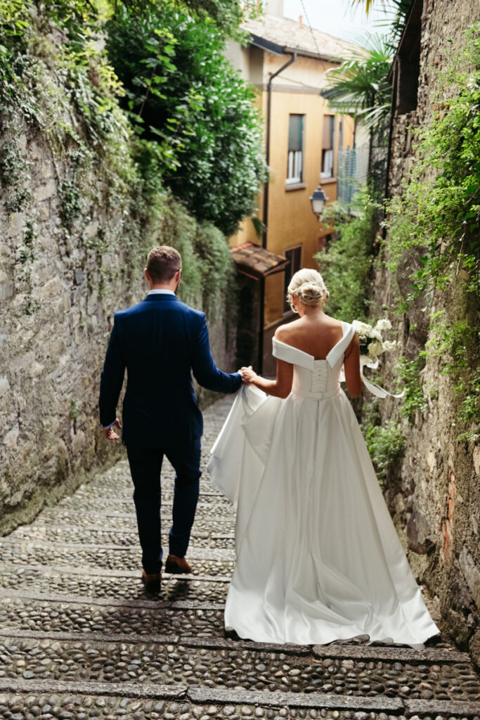 Groom leading the bride through a narrow cobblestone alley in a charming Italian village