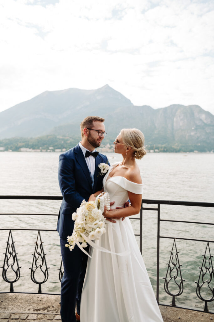 Bride and groom holding hands, sharing an intimate moment with a view of Lake Como