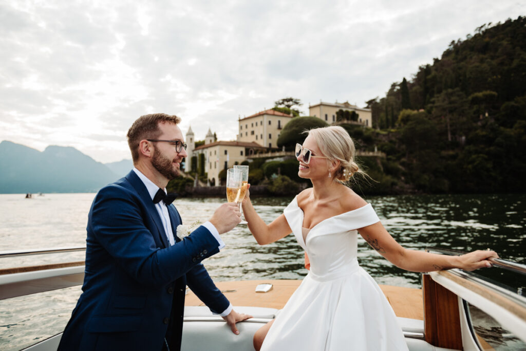 Bride and groom sharing a playful toast, laughing together on the boat