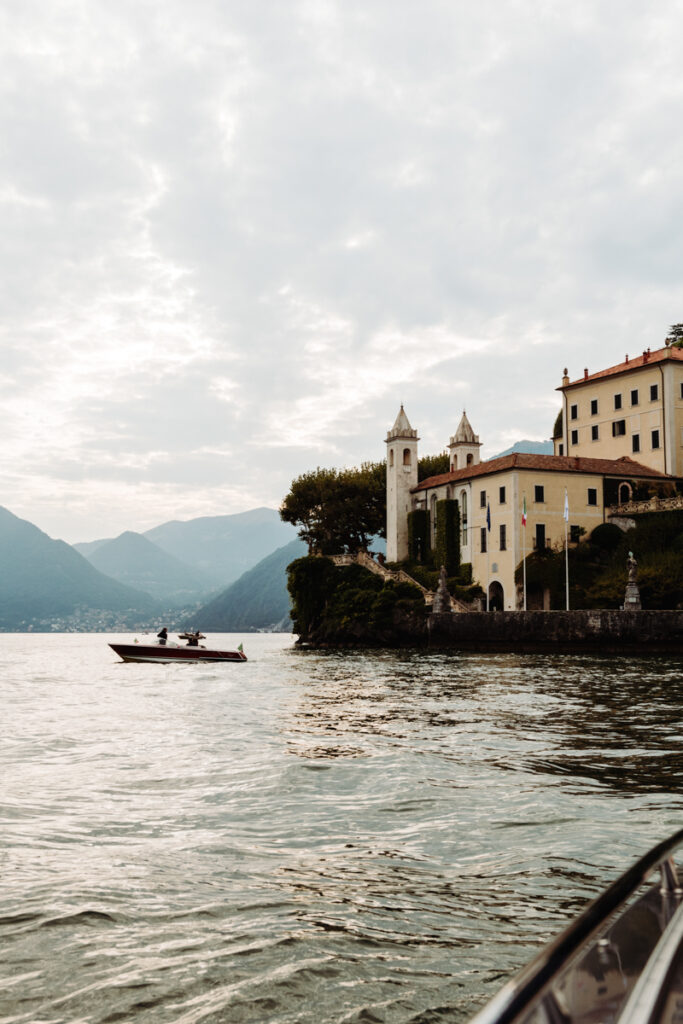 Sunset over Villa del Balbianello, with a boat on the calm waters of Lake Como