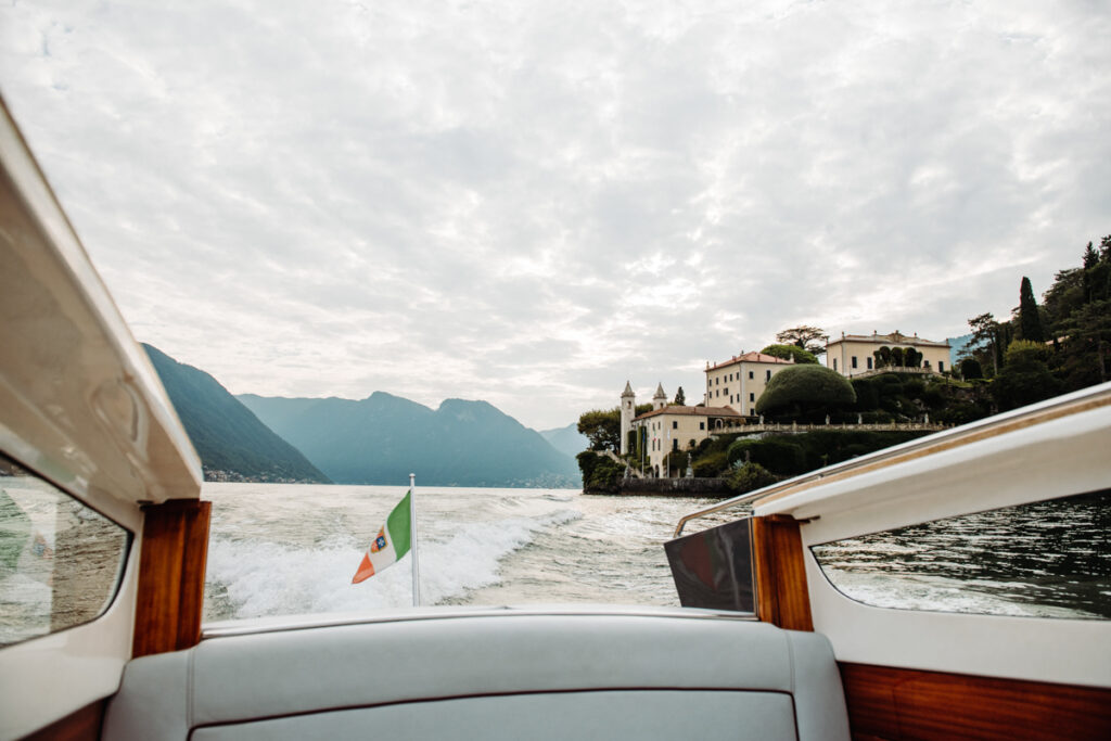 Boat cruising on Lake Como, passing by the historic Italian villa "Villa del Balbianello"