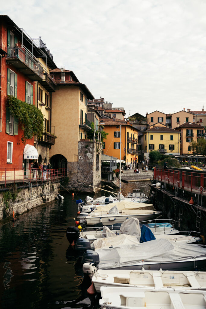 Picturesque canal with colorful buildings and boats in Varenna