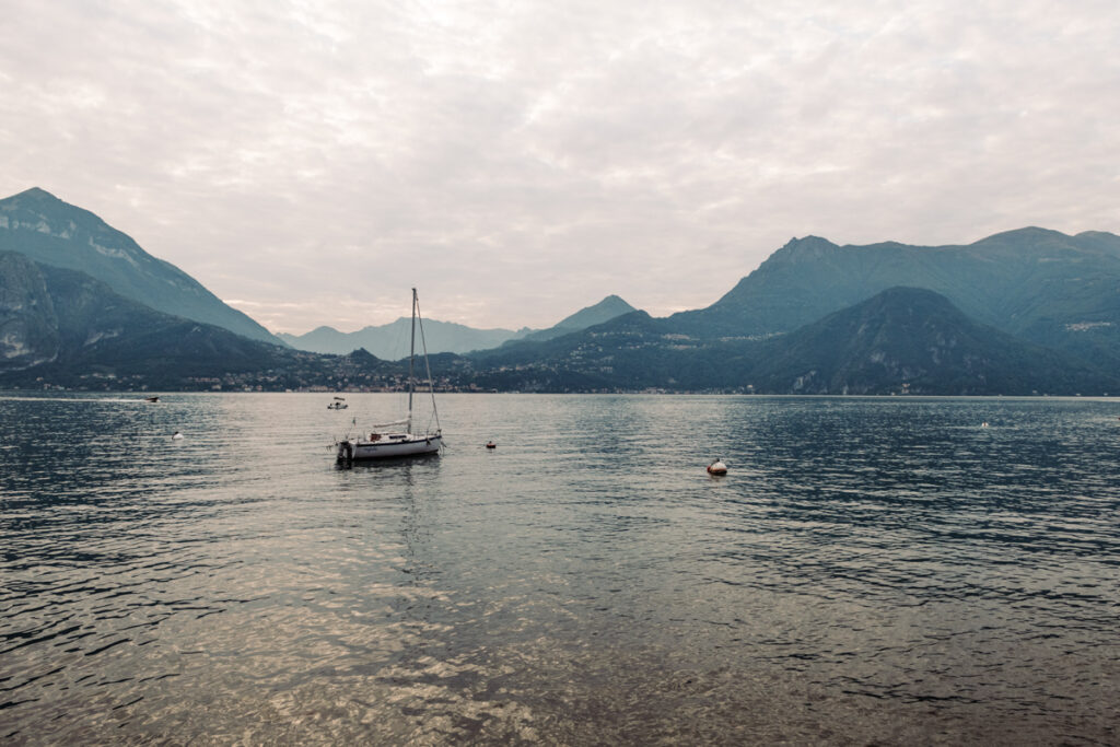 Peaceful view of a boat floating on the calm waters of Lake Como at dusk