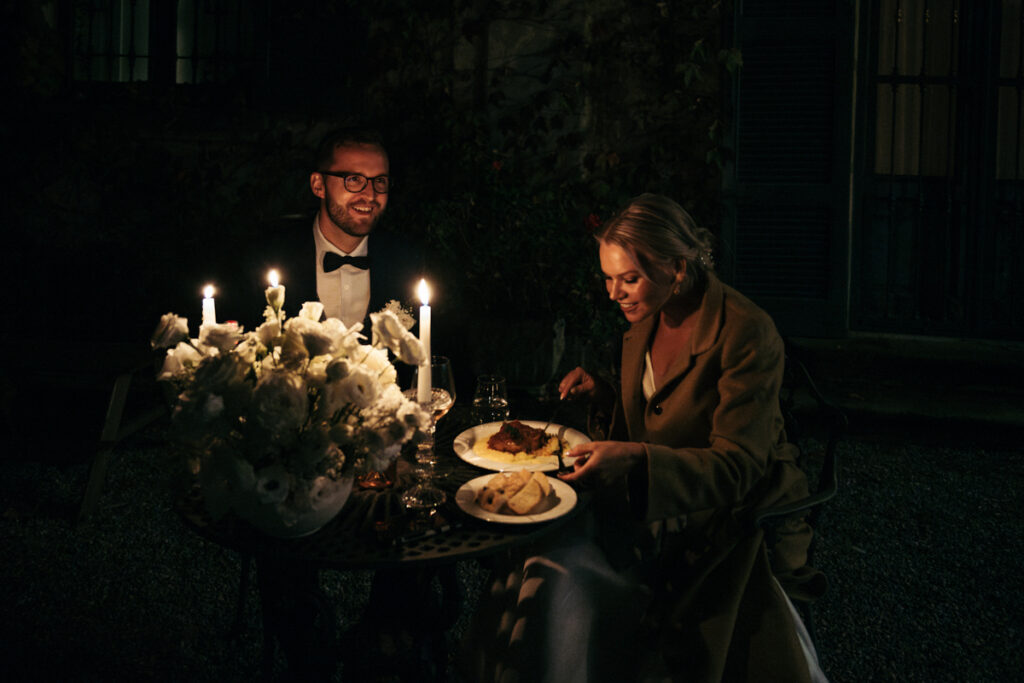 Bride and groom enjoying a romantic candlelit dinner during their intimate Italian elopement.