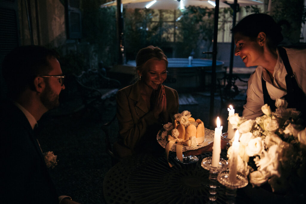 Bride and groom sharing a joyful moment while the chef brings their cake outdoors