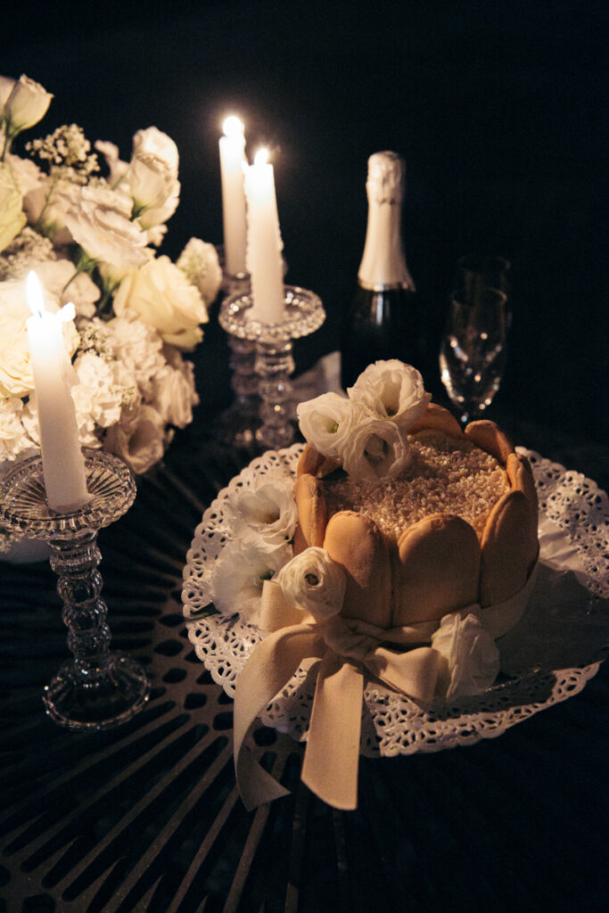 Elegant dessert table with candles, pastries, and champagne set for an intimate elopement dinner.