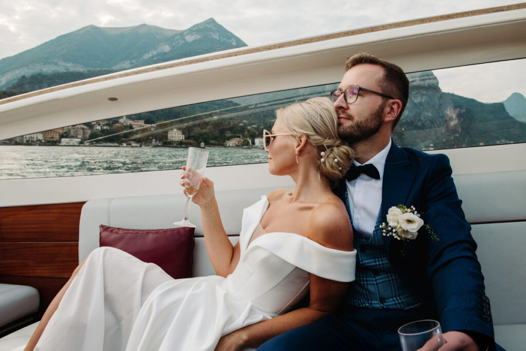 Bride and groom relaxing on a boat, enjoying champagne while cruising on Lake Como