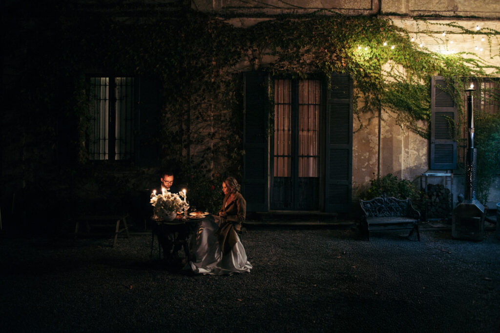 Bride and groom enjoying a private candlelit dinner outside a villa