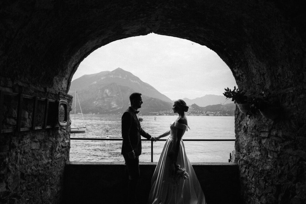 Bride holding her bouquet up against the backdrop of Lake Como