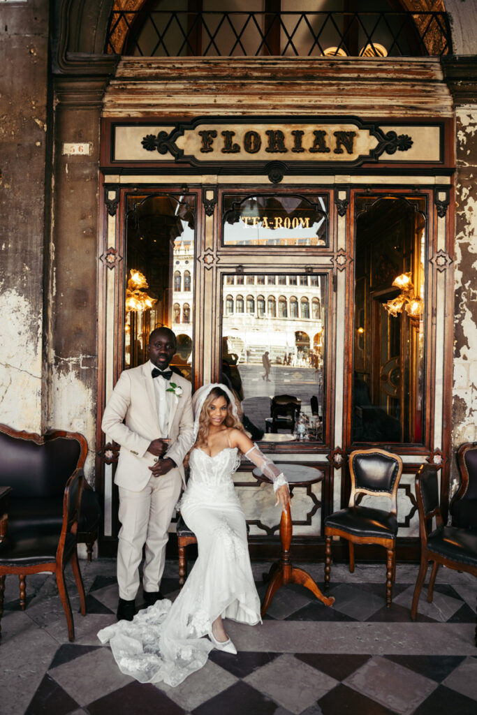 Bride and groom posing in front of the historic Caffè Florian in Piazza San Marco.