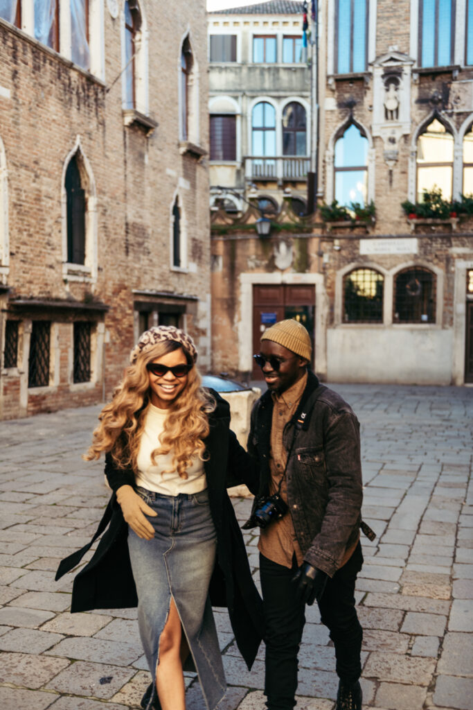 Playful moment between a couple exploring hidden corners of Venice.