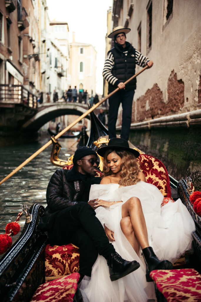 Romantic couple embracing on a gondola ride through the canals of Venice.