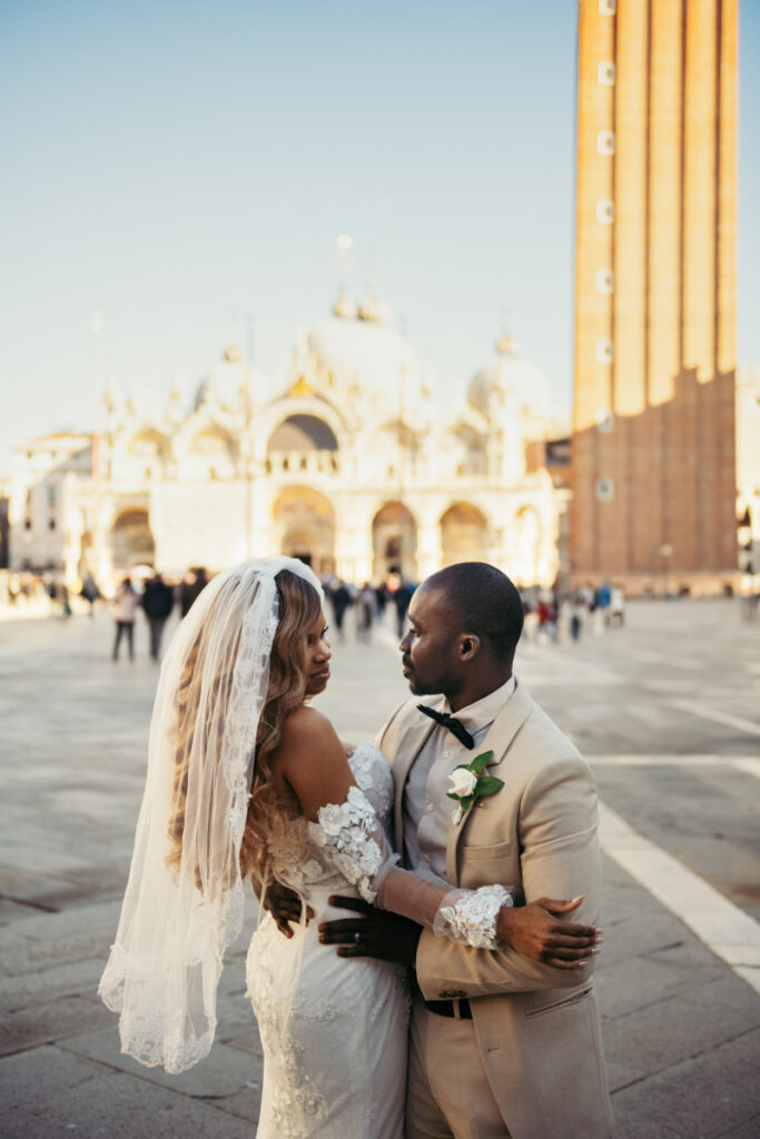 Newlyweds embracing in front of St. Mark’s Basilica early in the morning.