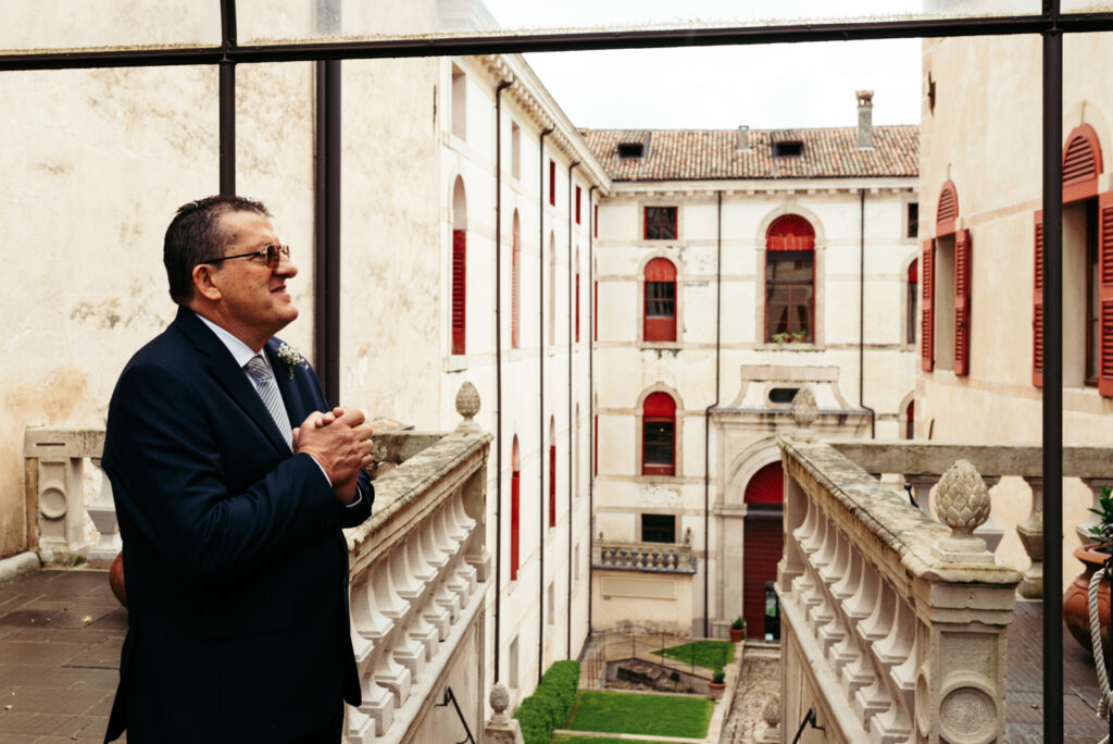 Father of the bride overlooking the castle courtyard before the ceremony begins.