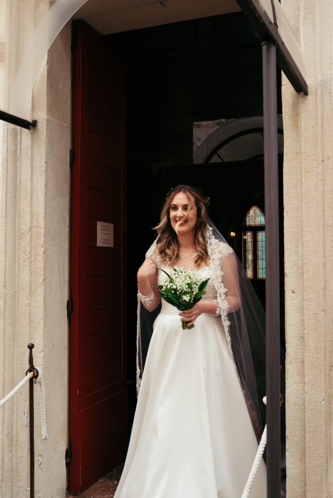 Bride with a joyful expression and bouquet in hand.