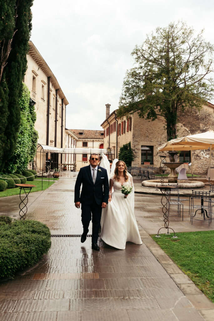 Bride and father walking through CastelBrando’s courtyard before the wedding.