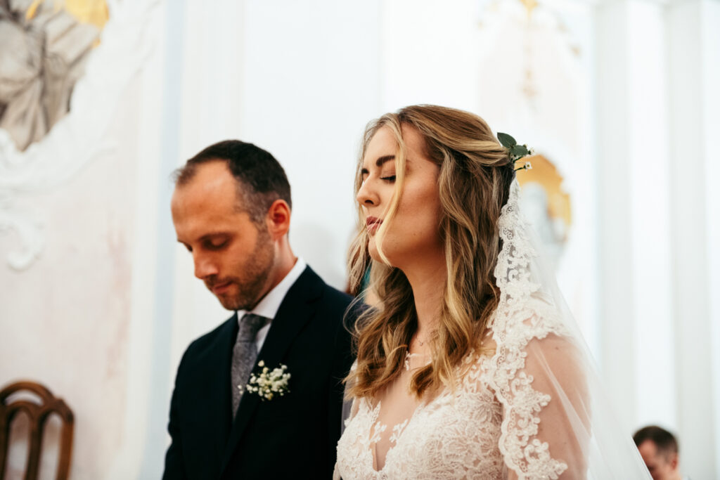 Groom and bride with their closed eyes during the ceremony
