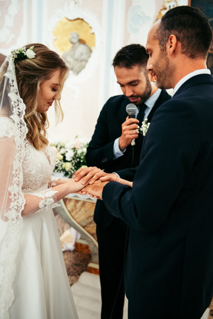 The officiant is completing the ceremony of the ring exchange