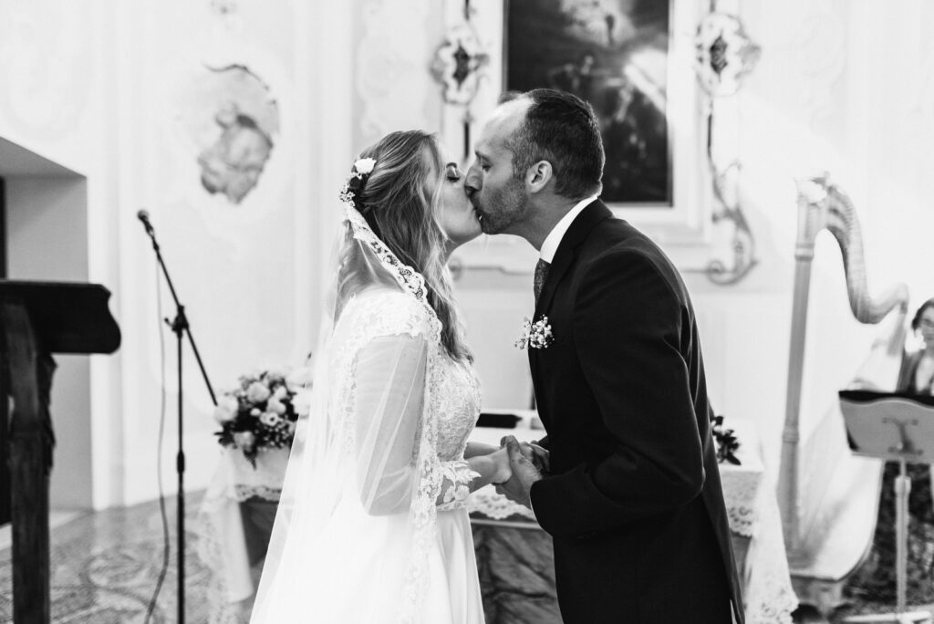 Black and white kiss at the altar after saying “I do” in CastelBrando’s chapel.