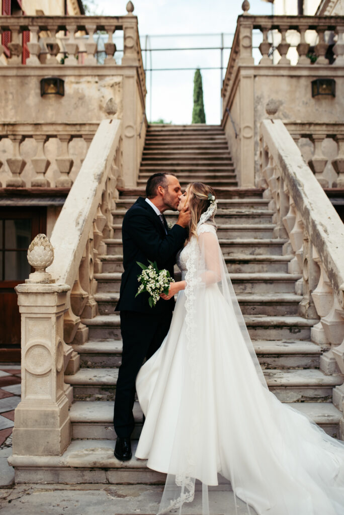 Groom and bride posing on the historic castle staircase, perfect for micro-wedding inspiration.