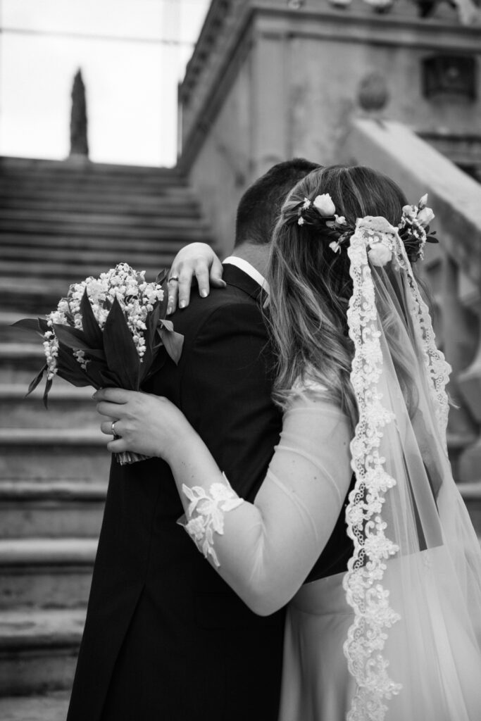 Romantic black and white photo of the bride hugging the groom after the ceremony.