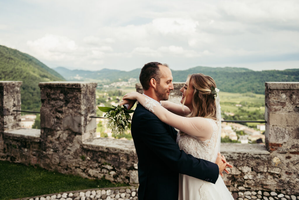 Bride and groom looking at each other with Valdobbiadene on the background