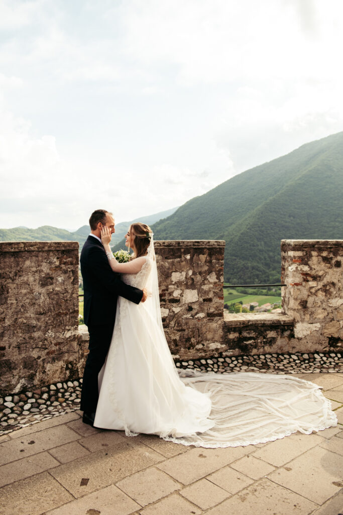 Romantic embrace on the castle’s stone terrace, perfect for an Italy destination wedding.
