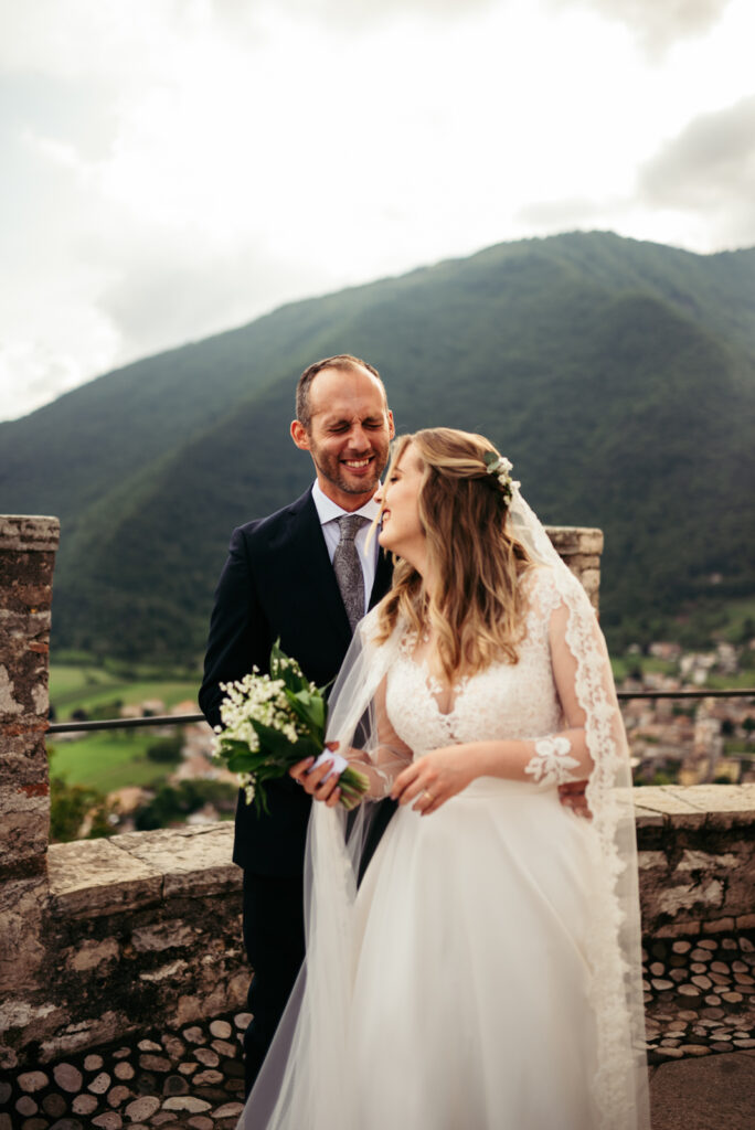Bride and groom smiling together on the castle terrace overlooking the Prosecco Hills.