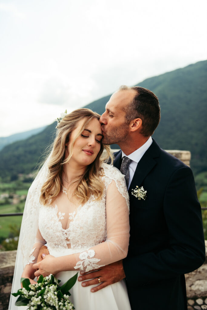 Groom kisses the bride's forehead in a quiet moment of joy.